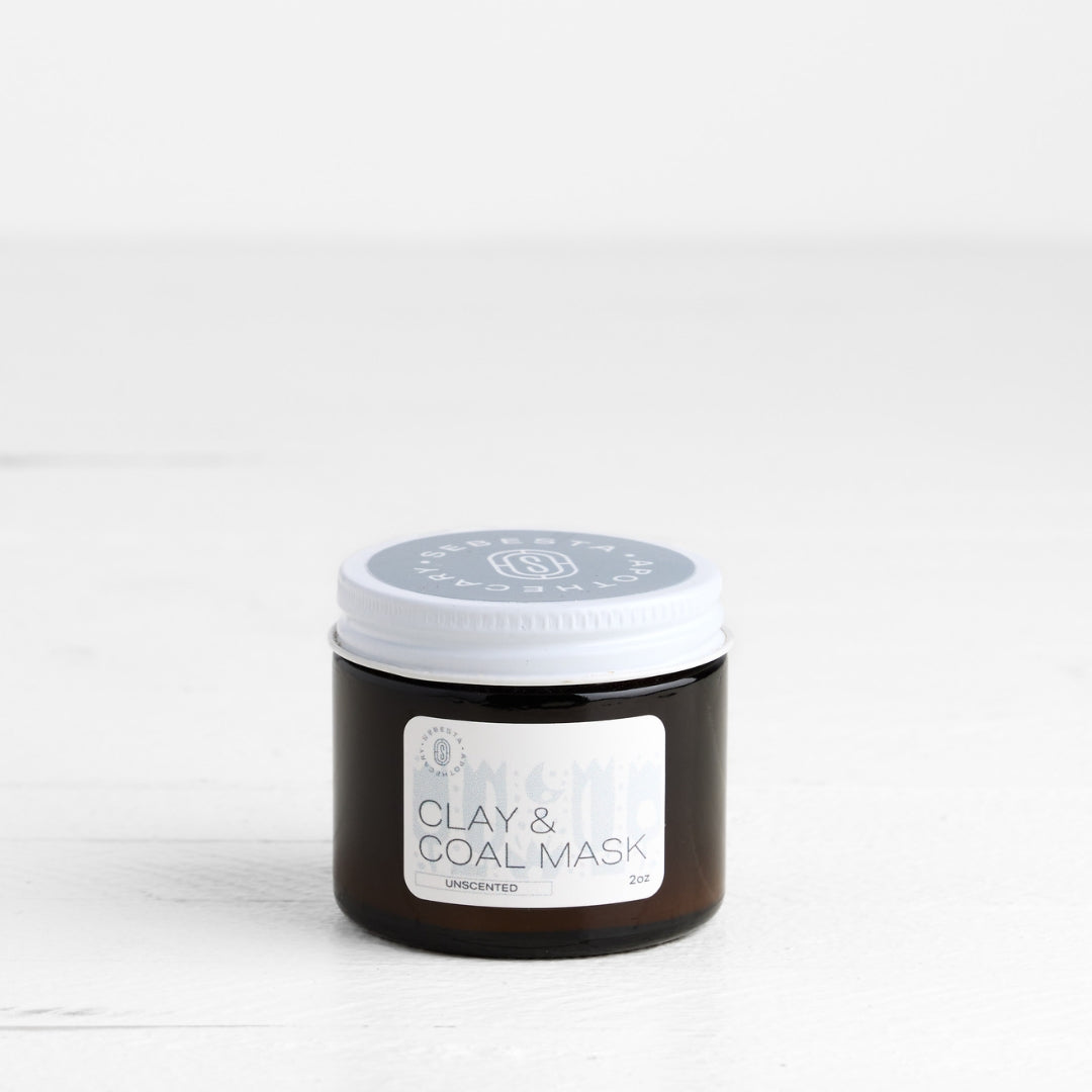 Jar of clay and coal mask on a white background