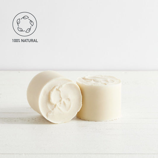 Sebesta Apothecary Two large round soap blocks one tipped on its side, laying on white background NATURAL logo