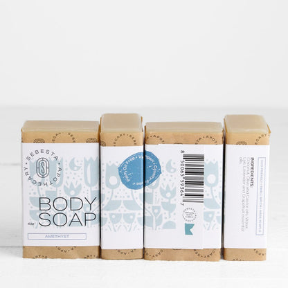 Four bars of body soap in paper wrap packaging on a white background