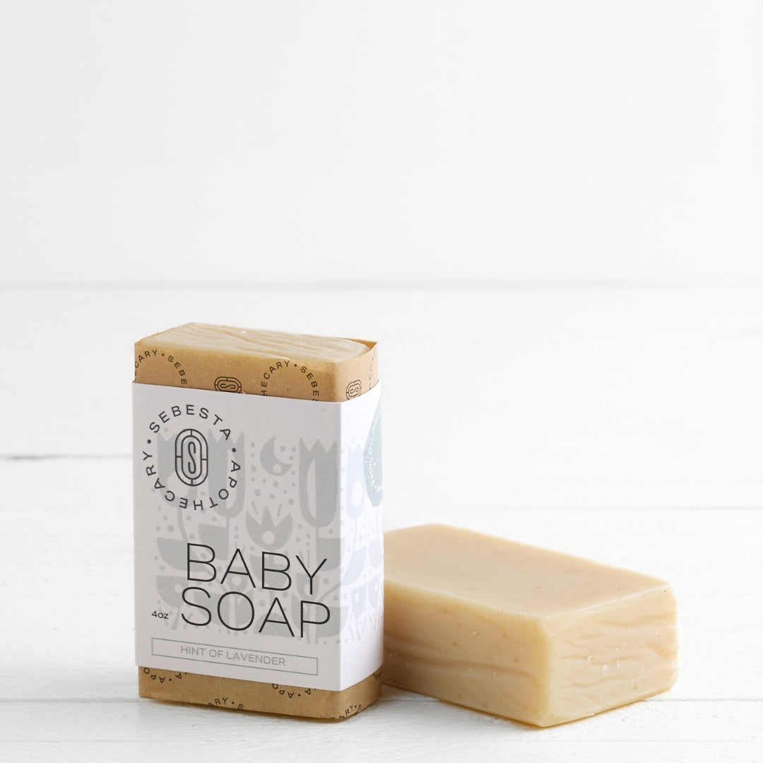 Two bars of Baby Soap Sebesta Apothecary Branding on a white background, one Tipped on side