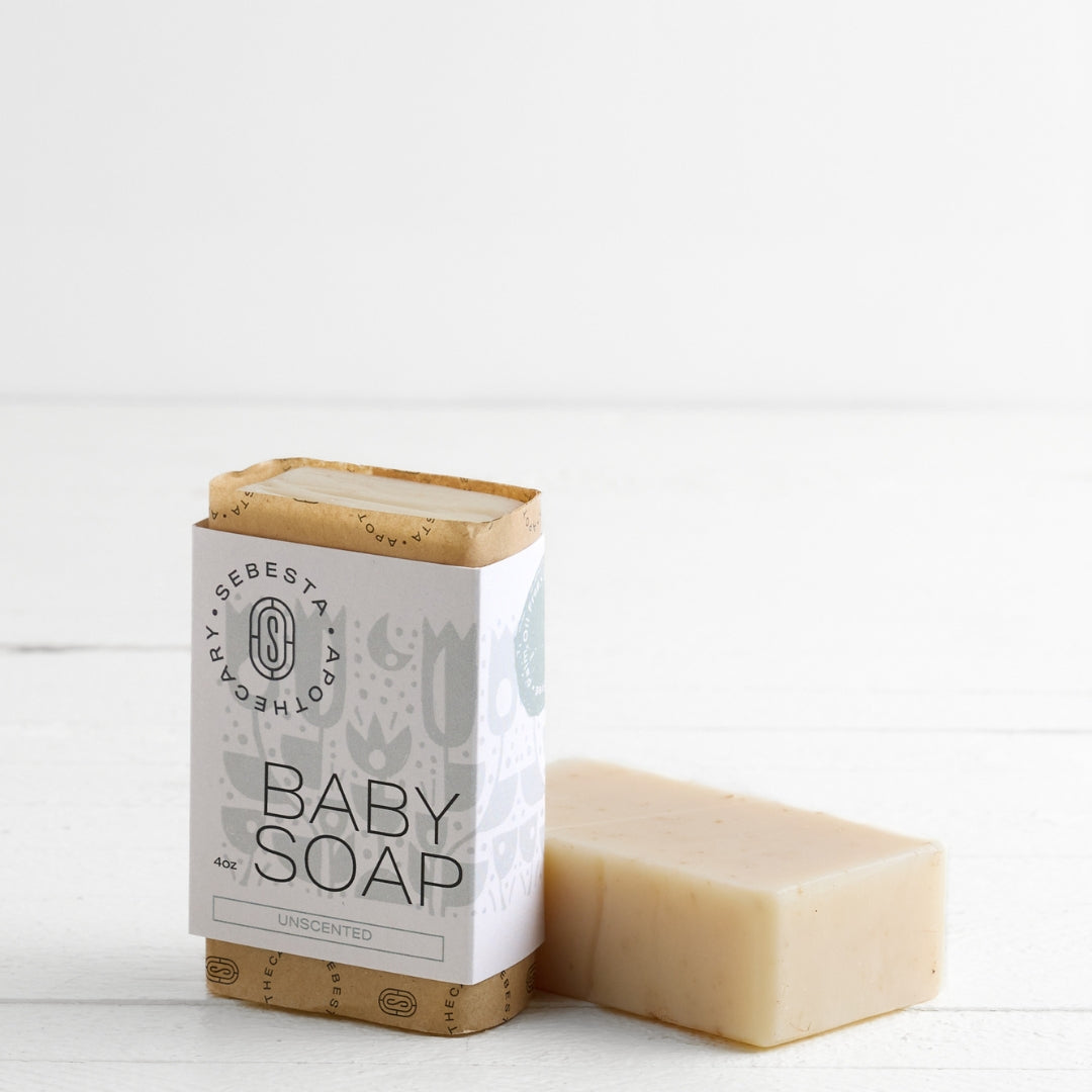 Two bars of Baby Soap Sebesta Apothecary Branding on a white background, one Tipped on side 