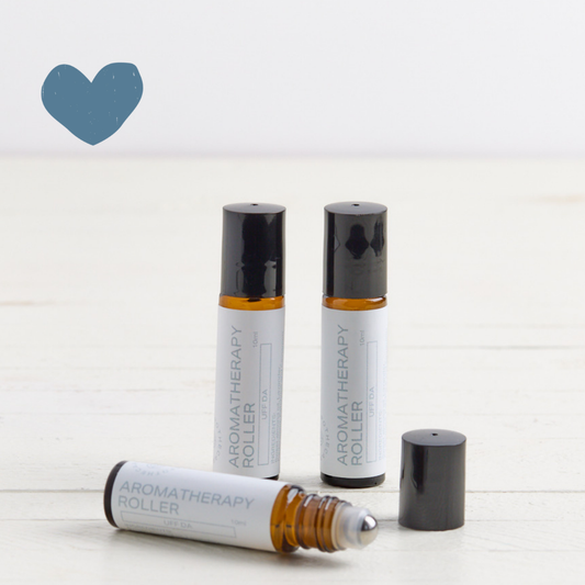 3 Sebesta Apothecary Aromatherapy Rollers on white table with white background. Sent called Uff Da. Blue heart icon top left