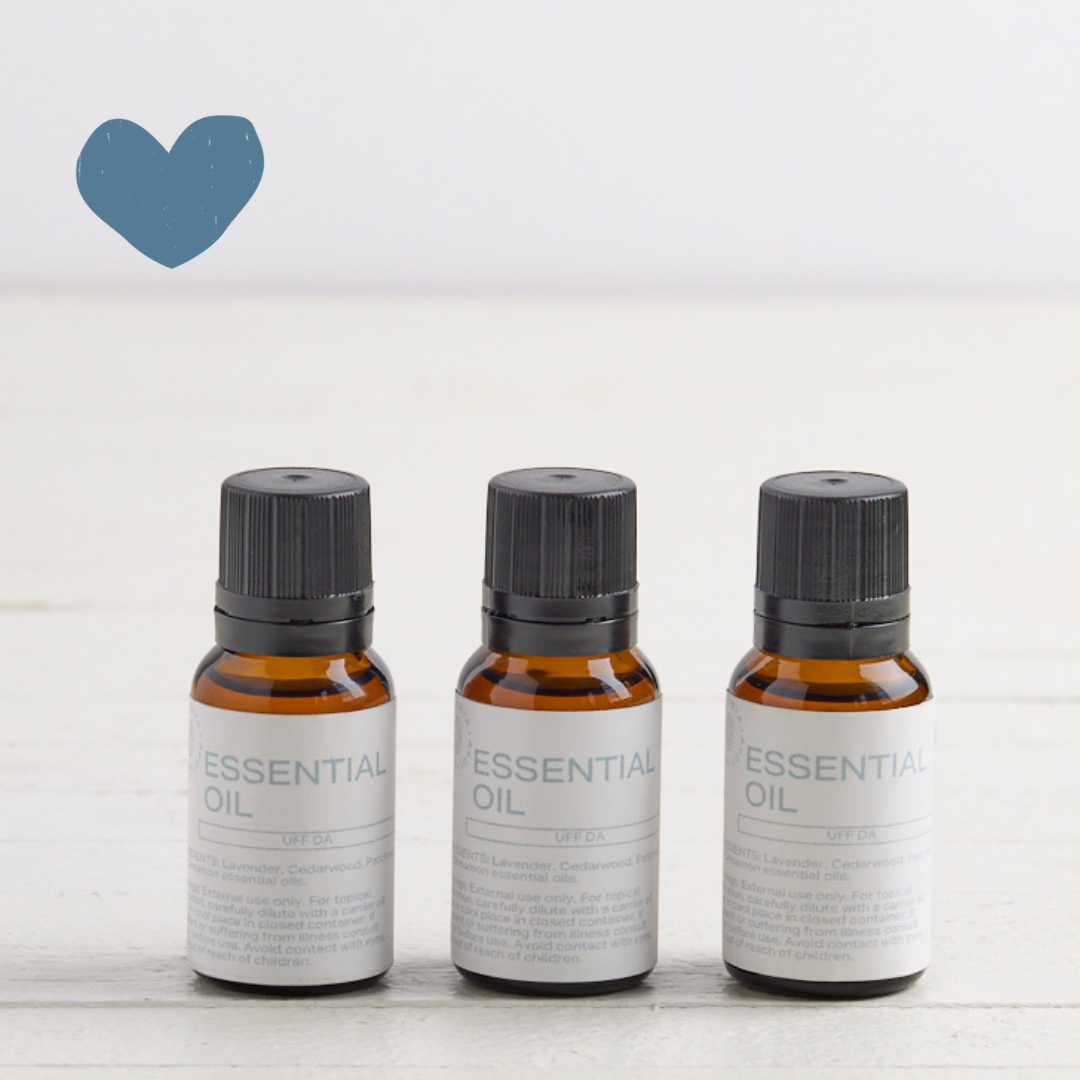 3 Sebesta Apothecary Essential oil bottles on white table with white background. Sent called Uff Da. Blue heart icon top left