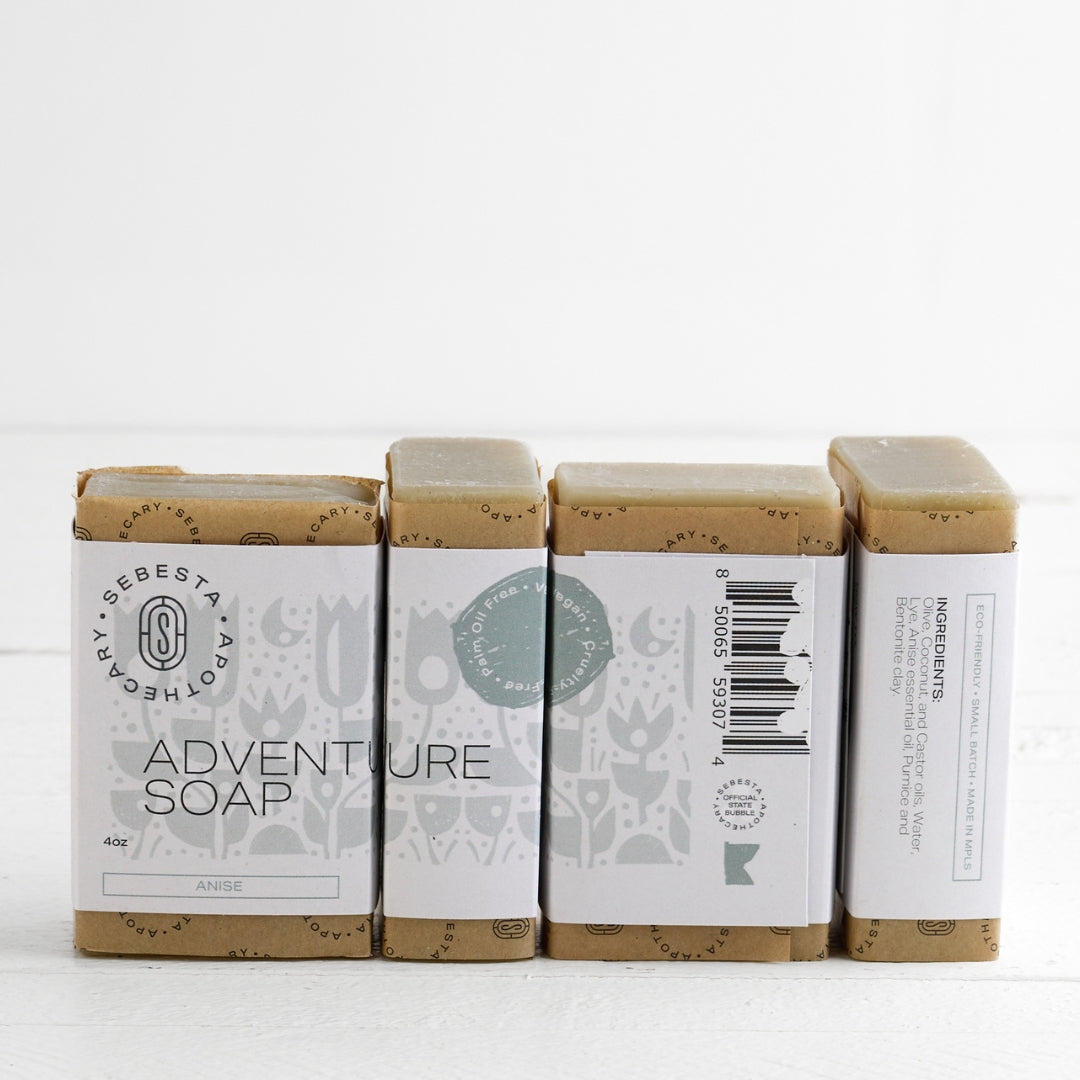 Four bars of 'Adventure Soap' by Sebesta Apothecary on a white background