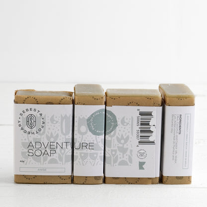 Four bars of 'Adventure Soap' by Sebesta Apothecary on a white background
