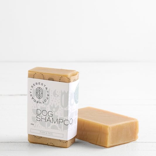 2 bars of Dog Shampoo Soap with Sebesta Apothecary Branding on a white background, one Tipped on side