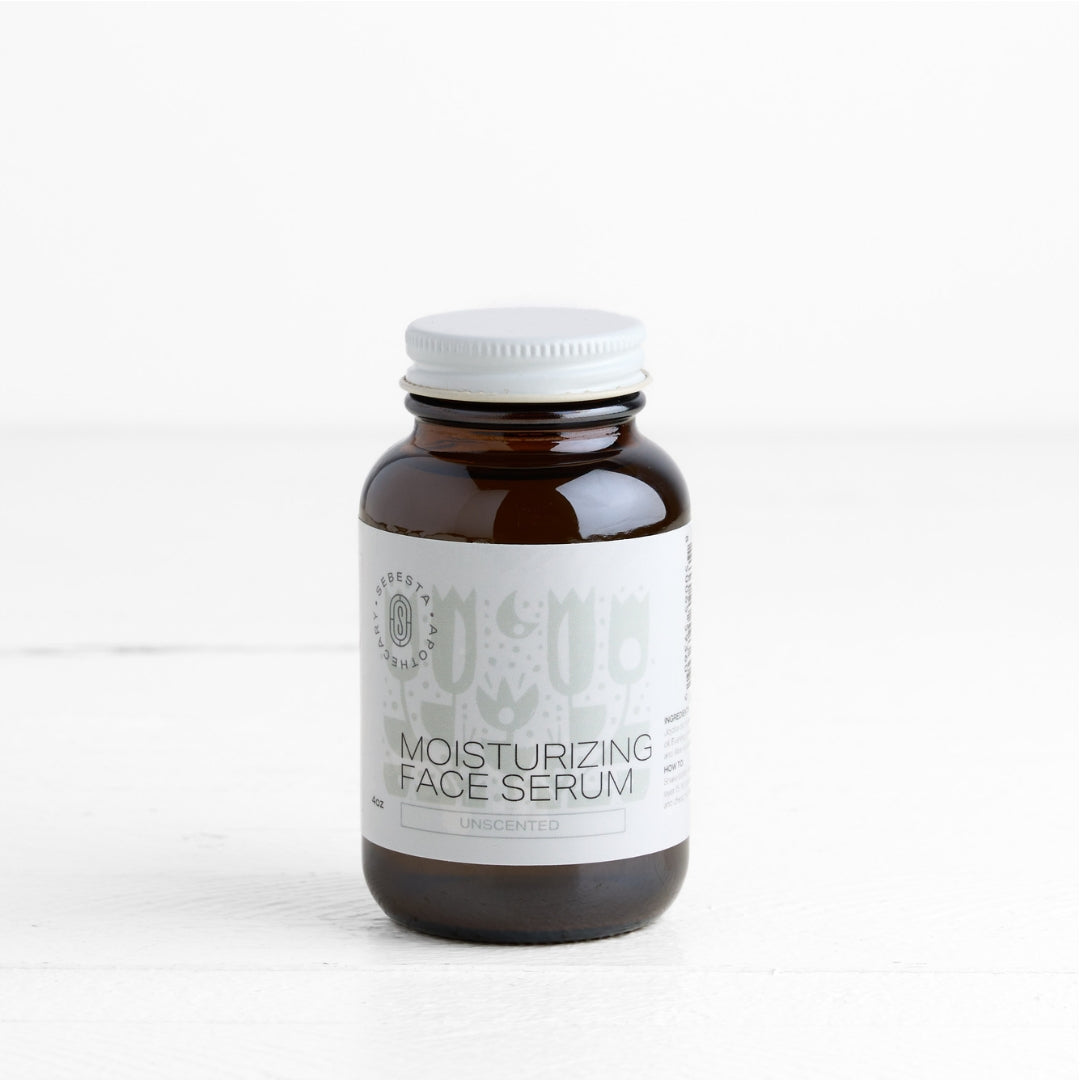 Brown bottle of moisturizing face serum with a white label on a white background