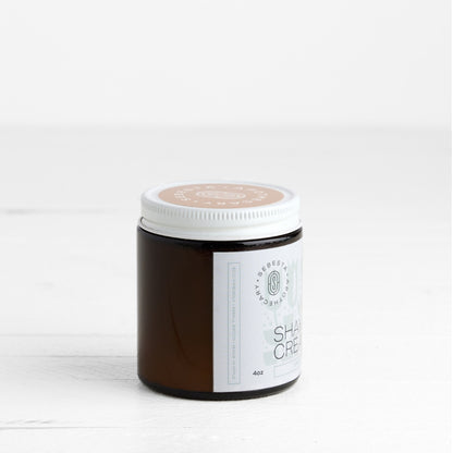 Jar of shaving cream with a white label on a light background